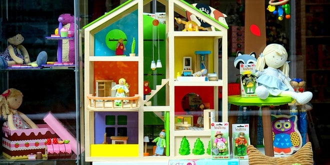 A doll house is displayed in a store window.