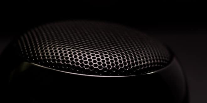 Close up of a black speaker on a black background.