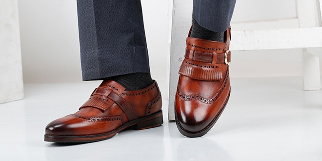 A man wearing a pair of brown leather shoes.