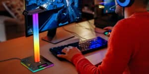 A man is playing a game on a computer with a rainbow light.