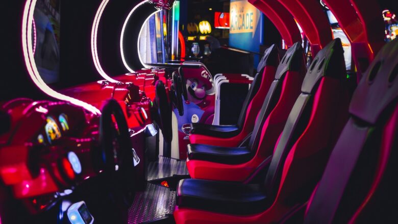 The inside of an arcade car with red and black seats.